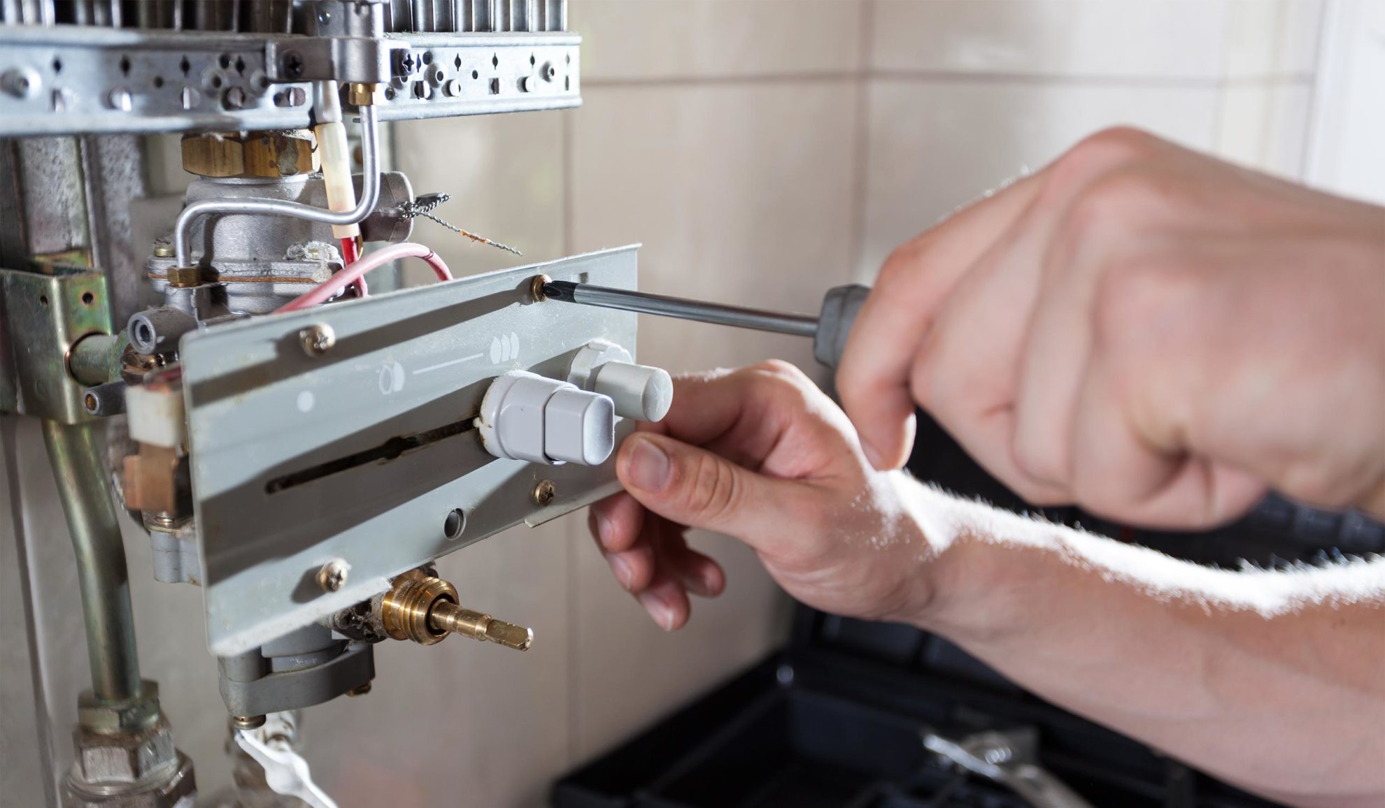 plumber hands close up with screwdriver repairing water heater dallas tx